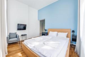 1 dormitorio con 1 cama blanca grande y 1 silla en Apartamenty Sun & Snow Międzyzdroje Promenada, en Międzyzdroje