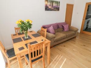 a living room with a table and a couch at Tarnacrye in Annan