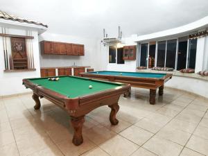 a pool room with two pool tables and windows at Casa del Cono in Cabo San Lucas