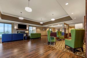an office lobby with green chairs and a table at Comfort Suites in Grand Island