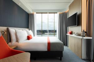 a hotel room with a bed and a large window at Holiday Inn Express Amsterdam - North Riverside by IHG in Amsterdam
