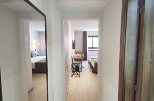 a hallway leading to a room with a bed and a mirror at DWO Nopal in Puerto de la Cruz