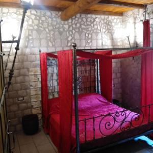 ein Schlafzimmer mit einem roten Bett in einer Steinwand in der Unterkunft Castle House in Cremona