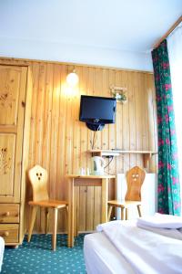 扎科帕内薇拉豪卡酒店的一间客房配有两张床、一台电视和两把椅子