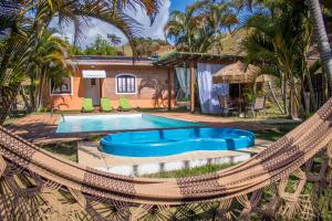 a pool with a hammock and a house at Pousada Sonho Meu in Itanhandu