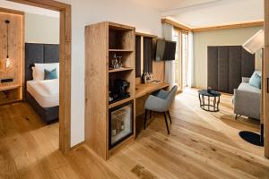 Pokój z łóżkiem, biurkiem i sypialnią w obiekcie Lake Spa Hotel SEELEITEN w mieście Caldaro
