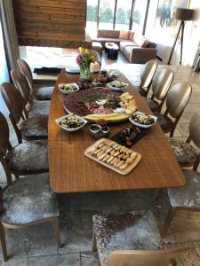 a wooden table with plates of food on it at Vila Antik in Garmen