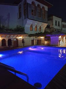 a swimming pool with blue lights in front of a house at Hotel Praga in Gjirokastër