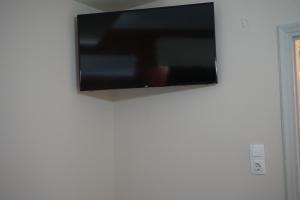 a flat screen tv hanging on a white wall at Orpheus Hotel in Athens