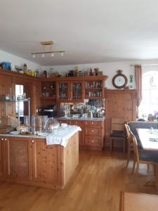 uma grande cozinha com armários de madeira e uma mesa em Hotel Pension Am Engelsberg em Sommerach