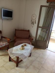 a living room with a table and a couch at Buganvilla Sea View apts in Agia Pelagia