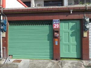 una puerta verde de garaje en un edificio con una puerta en Old street little house, en Chaozhou