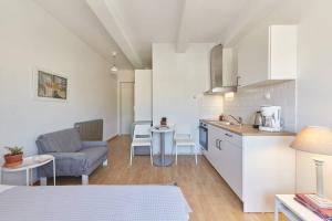 a kitchen and living room with a couch and a table at Bright Lovely Central Studio in Thessaloniki in Thessaloniki