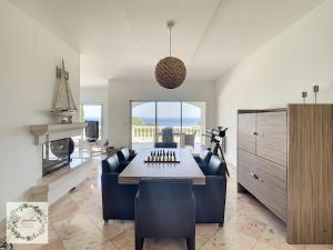 a living room with a table and chairs and a kitchen at Seaview villa Marlau in Macinaggio