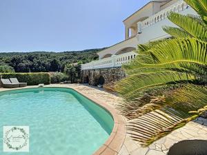 a swimming pool in front of a house at Seaview villa Marlau in Macinaggio