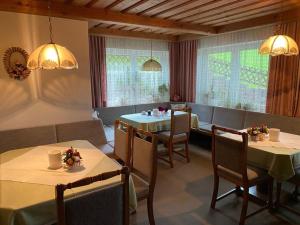 a dining room with two tables and chairs and windows at Gästehaus Lisbeth in Bad Kleinkirchheim