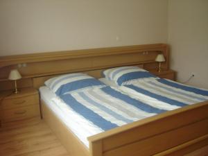 1 cama con 2 almohadas de rayas azules y blancas en Ferienwohnung Kathrin Kankel Alt Reddevitz, en Middelhagen