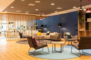 a lobby with chairs and couches and tables at Holiday Inn Express Amsterdam - North Riverside by IHG in Amsterdam