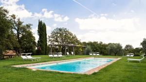 a swimming pool with lawn chairs and a gazebo at Casa Fabbrini Agriturismo in San Casciano dei Bagni