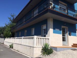 ein blaues Gebäude mit einem weißen Zaun davor in der Unterkunft Casamary Planta Alta in Pontevedra