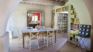 a dining room with a table and chairs and bookshelves at Casa Fabbrini Agriturismo in San Casciano dei Bagni