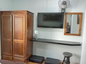 a room with a tv and a cabinet and a mirror at Faria Guimares Porto Centro in Porto
