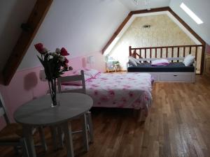 a bedroom with a bed and a table with a vase of flowers at les alouettes in Leschelles