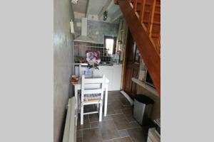 a small kitchen with a table and a table and chairs at les alouettes in Leschelles