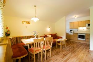 eine Küche und ein Wohnzimmer mit einem Tisch und Stühlen in der Unterkunft Kleinellmauhof in Großarl