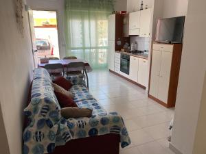 uma sala de estar com um sofá e uma cozinha em Appartamento nel cuore di Villasimius em Villasimius