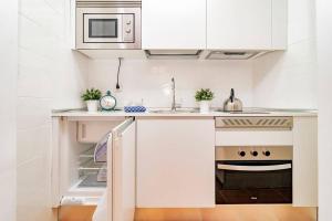 kuchnia z białymi szafkami i kuchenką w obiekcie Encantador Apartamento en Chueca junto a Gran Vía, Infantas 1-1 by Batuecas w Madrycie
