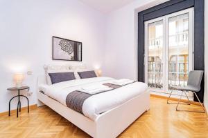 biała sypialnia z dużym łóżkiem i krzesłem w obiekcie Encantador Apartamento en Chueca junto a Gran Vía, Infantas 1-1 by Batuecas w Madrycie