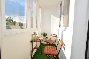 balkon z 2 krzesłami, stołem i oknem w obiekcie Apartament nad Strugą w Toruniu