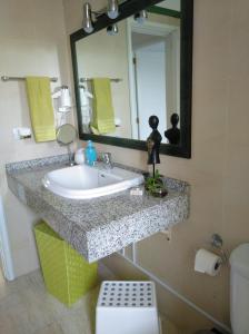W łazience znajduje się umywalka i lustro. w obiekcie 2 Calle las Azucenas w mieście Playa del Aguila