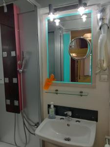 a bathroom with a sink and a shower and a mirror at Faria Guimares Porto Centro in Porto