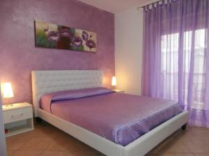 a bedroom with a bed and a window with purple curtains at Busalacchi B&B in Mondello