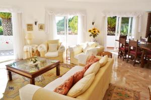 un salon avec des meubles blancs et une table dans l'établissement Casa Catryn, à Luz