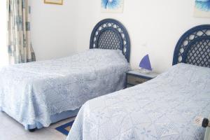 - une chambre avec 2 lits et des couettes blanches dans l'établissement Casa Catryn, à Luz