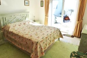 une chambre avec un lit avec une couverture dessus dans l'établissement Casa Catryn, à Luz