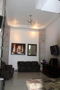 a living room with a couch and a tv at Hotel Gina in San Juan de los Lagos