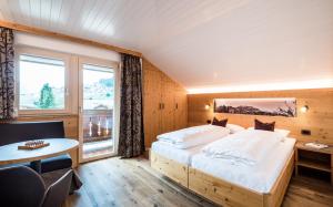 een slaapkamer met een groot bed en een raam bij Cesa Paula in Selva di Val Gardena