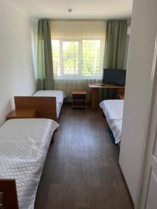 um quarto com três camas e uma janela em Готель em Bila Tserkva