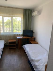 Zimmer mit 2 Betten und einem Schreibtisch mit einem Computer in der Unterkunft Готель in Bila Zerkwa