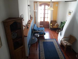 uma sala de estar com uma cadeira azul e uma porta em Casa Santa Ana em Lanjarón
