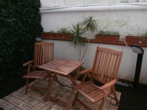 two chairs and a wooden table and chairs on a patio at Busalacchi B&B in Mondello