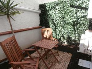 two chairs and a table on a patio with a plant at Busalacchi B&B in Mondello