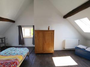 - une chambre avec un lit et une armoire en bois dans l'établissement Gîte La maison rose, à Hamois