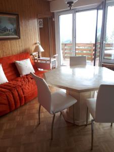 ein Wohnzimmer mit einem Tisch und einem Sofa in der Unterkunft LE NEVADA CRANS-MONTANA vue a vous couper le soufle in Crans-Montana