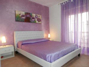 um quarto com uma cama e uma parede roxa em Busalacchi B&B em Mondello