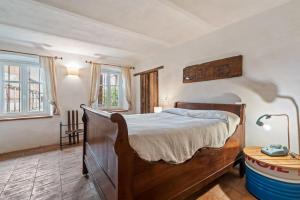 Un dormitorio con una gran cama de madera y una mesa. en Greeneria, en Guarene